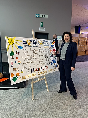 Manuela Ripa setzt sich u. a. wegen der Auswirkungen auf die menschliche Gesundheit für eine deutliche Reduzierung von Pestiziden ein. Das Foto zeigt sie im EU-Parlament vor einem Plakat der Child Cancer Campaign – Foto: Unicef